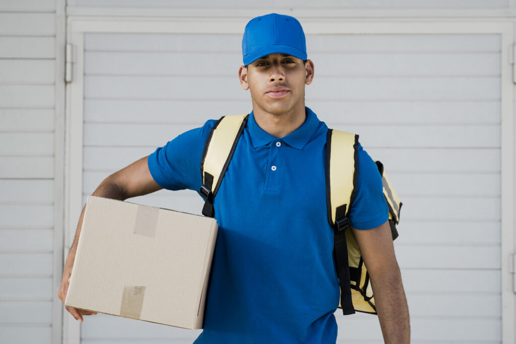 African delivery man holding box package for customer distribution - Focus on face